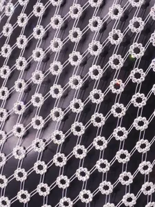 Vista macro del patrón floral de diamantes blancos en el tejido de malla del vestido