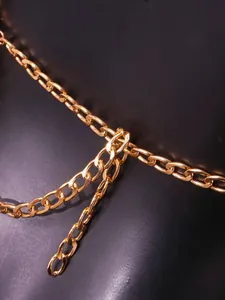 Detailed view of the shiny gold-colored metal chain strap on a stylish nightclub vest