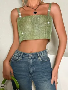 Detailed shot of a shimmering green rhinestone mesh crop top paired with stylish blue jeans