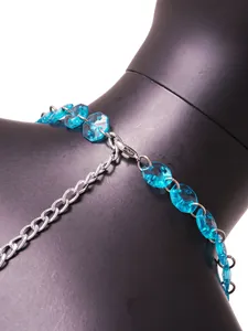 Detail van de blauwe edelsteenkralen en zilveren ketting van een haltertop met open rug