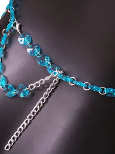 Detailopname van de blauwe zeshoekige edelsteenketting op een sexy haltertop