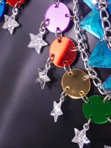 Detail view showing colorful acrylic discs and star charms on a festive silver body chain