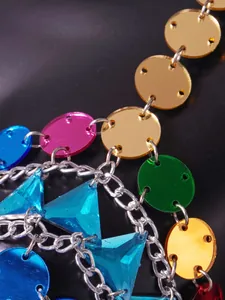 Close-up of vibrant multicolored acrylic discs and blue gems on a silver body chain