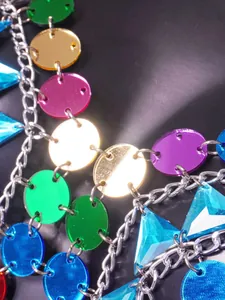 Close-up detail of vibrant multi-colored acrylic circle and triangle body chain links