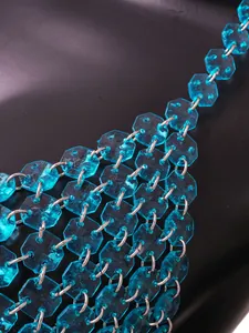 Macrodetail van helderblauwe achthoekige acrylstenen met zilveren metalen ringen