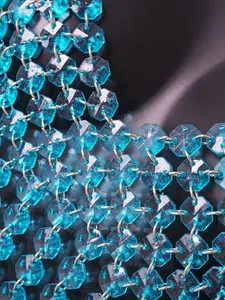 Detail van turquoise haltertop met achthoekige acryl edelsteenkettingen voor feestkleding