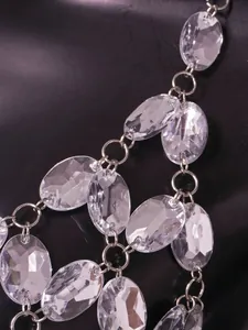 Close-up detail showing clear faceted faux gems linked by silver-tone rings in a body chain