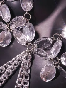 Exquisite close-up of clear faceted faux gemstones and polished silver metal body chain vest