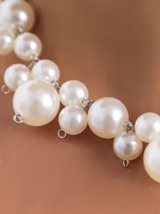Makrodetail eines eleganten, klobigen Chokers aus Kunstperlen mit silbernen Verbindungsringen