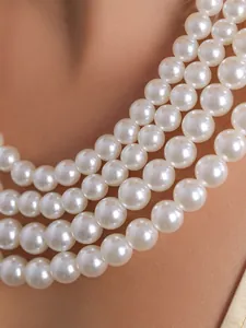 Detailaufnahme einer mehrlagigen weißen Perlenkette mit elegantem Glanz und Textur