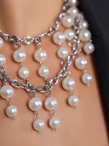 Detailaufnahme einer doppellagigen klobigen Perlenhalskette mit Quasten für Damen.