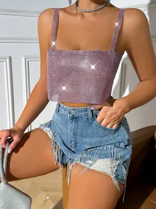 Close-up detail of sexy pink rhinestone crop top with sparkly fringe denim shorts