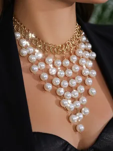 Detailaufnahme einer klobigen Goldkette mit kaskadierenden weißen Kunstperlen-Quasten