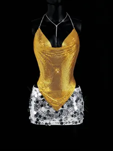 Detailed view of shiny gold metallic mesh halter top paired with silver sequin skirt.