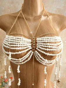 Close-up detail of an elegant white beaded pearl body chain with gold star pendants
