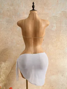 Chic golden beaded body chain accessory paired with a white mesh wrap sarong skirt on mannequin