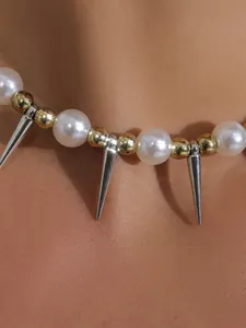 Nahaufnahme einer modischen Choker-Kette mit großen Perlen und silbernen Spike-Anhängern