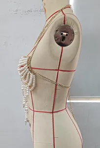 Detailed side view of an elegant pearl beaded body chain on a mannequin.