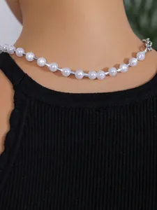 Nahaufnahme einer eleganten weißen Perlenkette mit Silberperlen am Modell