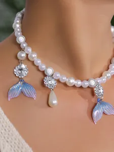 Nahaufnahme von Perlenhalskette mit schillernden blauen Meerjungfrauenschwänzen und Kristallen.