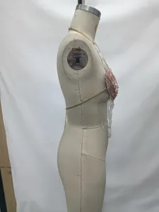 Side view detail of a shell body chain with gold chains and white beads on a mannequin
