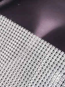 Close-up of shiny rhinestone mesh fabric on a sexy fishnet camisole top.