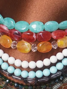 Dettaglio di una catena per il corpo fatta a mano con perle acriliche colorate