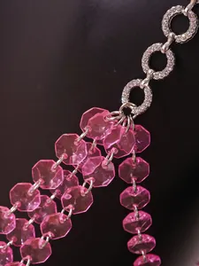 Close-up detail of pink translucent beads and rhinestone rings for sexy halter camisole.