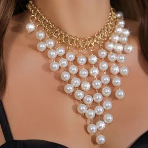 Grobe goldfarbene Kette mit eleganten, kaskadierenden weißen Kunstperlenfransen als Detail.