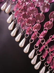Macro detail view of elegant pink faceted crystal gems and teardrop pearl fringe