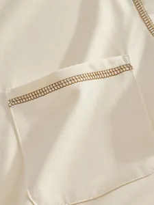 Detailansicht der braunen Kontrastnähte an der Tasche des cremefarbenen Herren-Poloshirts