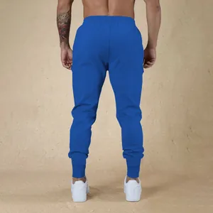 Vista posteriore di pantaloni sportivi blu da uomo con polsini per fitness in palestra