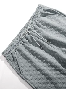 Dettaglio pantaloncini in maglia a nido d'ape grigi con elastico e coulisse bianca