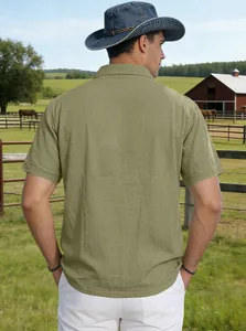Rückansicht eines atmungsaktiven olivgrünen Leinen-Poloshirts in ländlicher Umgebung