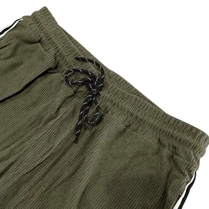 Detailansicht einer olivgrünen Cordhose mit elastischem Bund und Kordelzugverschluss.