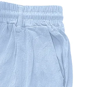 Detail view of breathable light blue cotton linen trousers with elastic waistband texture