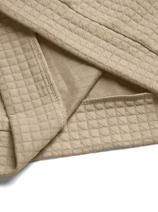 Close-up of men's khaki waffle knit jacket fabric showing texture and stitching.