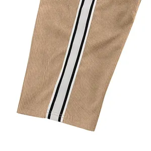 Detailansicht der Cordstruktur und der weiß-schwarzen Seitenstreifen an einer beigen Herrenhose