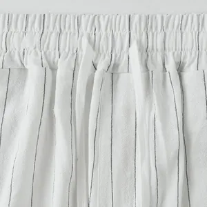 Close-up detail of drawstring waistband on white striped linen casual summer pants