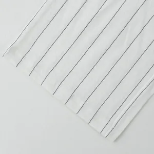 Macro view of white linen fabric with thin black vertical stripes for casual trousers.