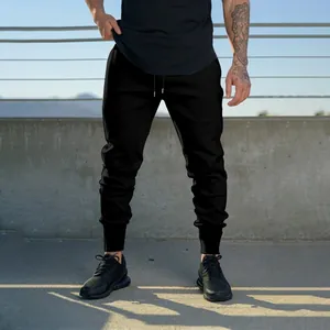 Pantaloni sportivi neri slim da uomo presentati in un contesto di fitness urbano.