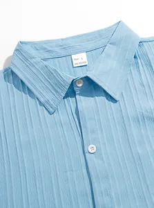 Primo piano del colletto della camicia in seersucker blu con bottoni e etichetta taglia L