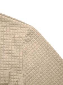 Close-up of beige waffle knit jacquard fabric texture on a men's casual jacket
