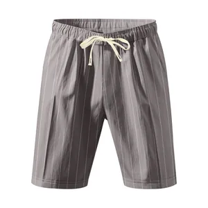 Macro view of men's grey vertical striped linen beach shorts with cream drawstring detail.