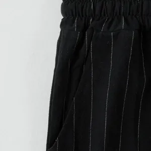 Macro detail of vertical pinstripe pattern on black breathable linen pants for men