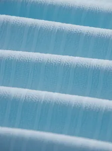 Primo piano del tessuto strutturato azzurro con motivo a coste verticali