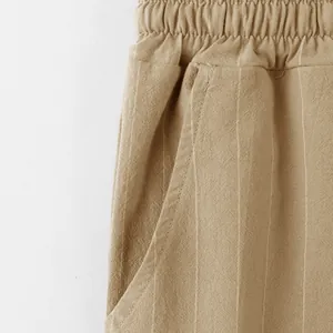 Macro view of khaki linen-blend summer pants showing vertical stripes fabric texture and pocket.