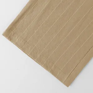 Close-up of khaki linen fabric with white vertical stripes and stitched hem detail