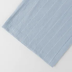 Close-up detail of light blue vertical striped linen fabric and hem stitching