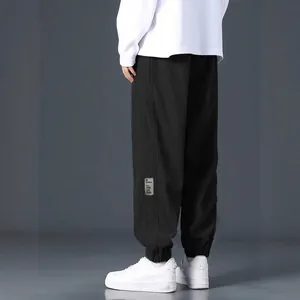 Loose fit men's black corduroy pants for casual streetwear style with side patch details